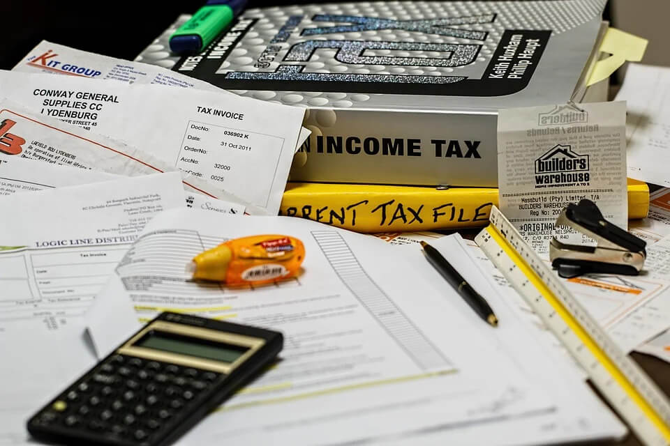 desk covered with tax papers and books