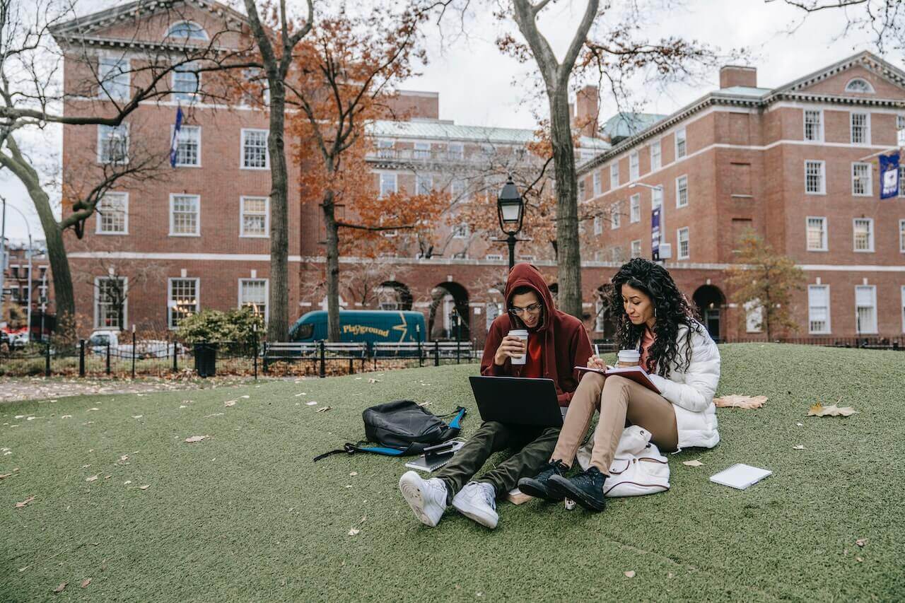 two students studying outdoors on campus