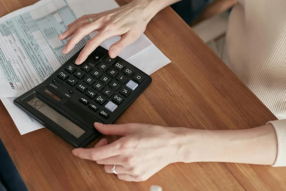 woman using calculator to fill out a document